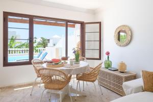 a dining room with a table and chairs with a view at VILLA ERIC with a private stunning heated pool in Puerto del Carmen