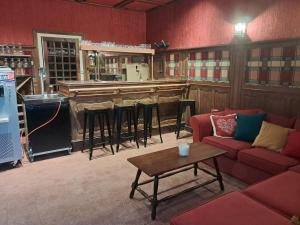 a living room with a bar with a couch and a table at Chalet de la source in Prades