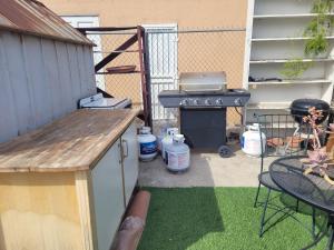a backyard with a grill and a table and chairs at Urban Farm House +Hot Tub+Pool in Long Beach