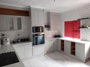 a white kitchen with white cabinets and a microwave at 04 at Beaumont in King Williamʼs Town