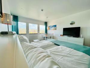 a bedroom with two beds and a flat screen tv at Ferienwohnung Südanker Fehmarn in Fehmarn