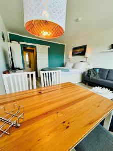 a dining room with a wooden table and a bedroom at Ferienwohnung Südanker Fehmarn in Fehmarn +10 photos