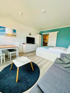 a bedroom with a bed and a desk and a table at Ferienwohnung Südanker Fehmarn in Fehmarn