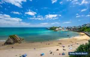 een groep mensen op een strand vlakbij de oceaan bij Lilac Cottage in Tenby