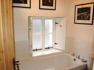 a bathroom with a bath tub and a window at Foxhole in Threlkeld