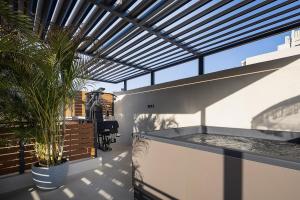 a house with a patio with a table and a plant at Pappous & Giagia Central Suites, By IdealStay Experience in Malia