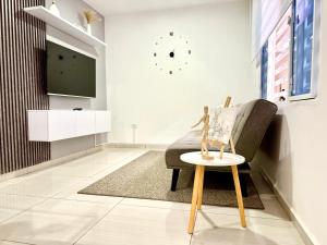 ein Wohnzimmer mit einem Stuhl und einem TV in der Unterkunft Elegance in the heart of wine in Lemos