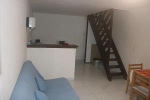 a living room with a blue couch and a staircase at Appartement charmant au Gosier, 60 m², terrasse in Le Gosier