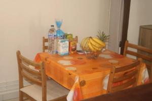 a table with a bowl of bananas and drinks on it at Appartement charmant au Gosier, 60 m², terrasse in Le Gosier