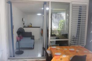 a dining room with a table and a chair at Appartement charmant au Gosier, 60 m², terrasse in Le Gosier +4 photos