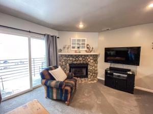 a living room with a fireplace and a flat screen tv at 14-Plex 218 in Garden City