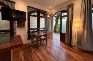a living room with a wooden table and a television at Paseo Colonial - Leo's Favorite #8 in Santo Domingo