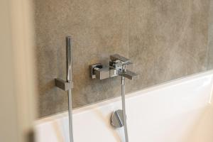 a bathroom with a bath tub with a faucet at Ferienhaus Lake Residence Müritz in Rechlin +35 photos