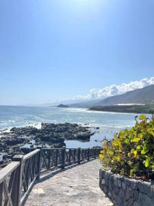 a walkway leading to the ocean with mountains in the background at Casa Vacacional Nona in Caleta de Interián