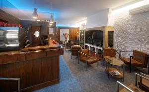 a waiting room with a bar and some chairs at Hôtel Le Lons in Foix