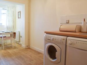 a kitchen with a washing machine and a table at Valeview Cottage in Great Malvern