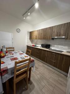 a kitchen with a table with chairs and a kitchen with wooden cabinets at Casa Vacacional Nona in Caleta de Interián