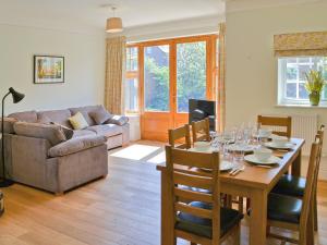 a living room with a table and a couch at Three The Boulevard in Sheringham