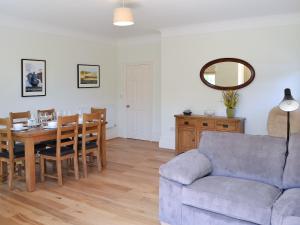 a living room with a table and a blue couch at Three The Boulevard in Sheringham