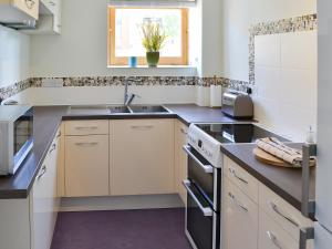 a kitchen with a sink and a stove top oven at Three The Boulevard in Sheringham +9 photos