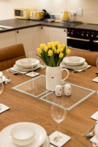 einen Tisch mit einer Vase gelber Blumen darauf in der Unterkunft Holiday Home Balbeg Cottage by Interhome in Straiton