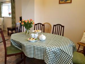 une table avec des assiettes de nourriture et des fleurs dessus dans l'établissement Hay Rick - Ukc2401, à Luton
