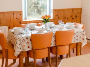 ein Esszimmer mit einem Tisch mit Stühlen und einer Vase aus Blumen in der Unterkunft Holiday Home Doonans Cottage by Interhome in Straiton