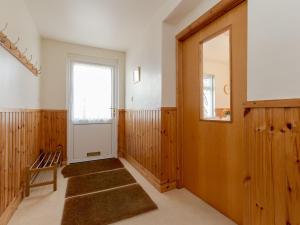 einen Flur mit einer Tür, einem Stuhl und einem Fenster in der Unterkunft Holiday Home Doonans Cottage by Interhome in Straiton