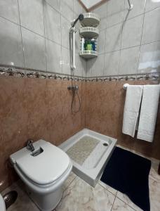 a bathroom with a toilet and a shower in it at Casa Vacacional Nona in Caleta de Interián +16 photos