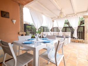Un comedor con una mesa y sillas blancas. en Apartment La Veranda di Mirko by Interhome, en Porto Rotondo
