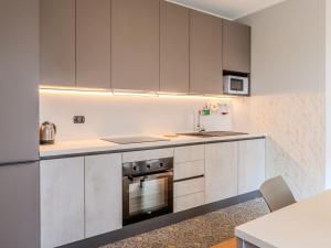 a kitchen with white cabinets and a sink and a stove at Apartment Casa Dolce Vita by Interhome in Gravedona +21 photos