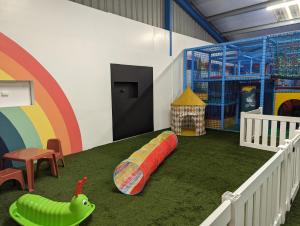 a room with a playground with a rainbow on the floor at Fallow Fields Camping, Lathe Barn in Burmarsh