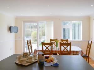 a kitchen and dining room with a table and chairs at Driftwood in Port Isaac