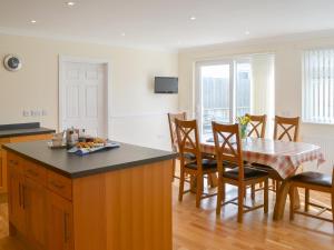 a kitchen and dining room with a table and chairs at Driftwood in Port Isaac