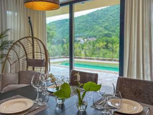 a dining table with glasses and a view of a pool at Villa Villa Perla di Draga by Interhome in Mošćenička Draga