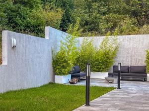 a patio with two black couches in the grass at Villa Villa Perla di Draga by Interhome in Mošćenička Draga +27 photos
