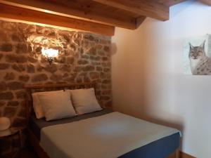 un letto in una stanza con un muro di pietra di Bâtisse Ardechoise avec piscine a Saint-Prix Altre 17 foto