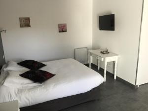 een slaapkamer met een wit bed en een kleine tafel bij Chambres d'Hôtes Le Mas du Bijou Bleu in Puget-sur Argens