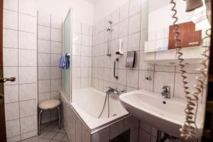un bagno con lavandino e vasca da bagno di Hotel Alter Telegraf a Graz