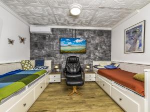 a bedroom with two beds and a chair at Holiday Home Mediana by Interhome in Balatonmáriafürdő +11 photos