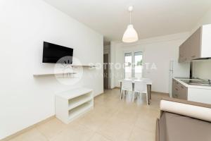 kuchnia i jadalnia z białymi szafkami i stołem w obiekcie Ungaretti Resort w mieście Porto Cesareo