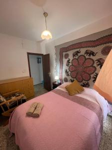 a bedroom with a large bed with two towels on it at apartamento la fortuna in Carabanchel Alto