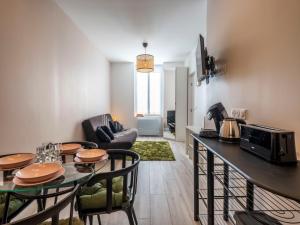 a kitchen and living room with a table and chairs at Studio centre ville La Bourboule in La Bourboule