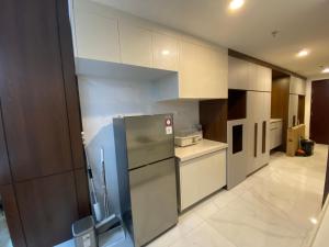 a kitchen with white cabinets and a stainless steel refrigerator at Sky House BSD in Samporo