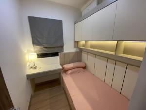 a small room with a bed and a desk with a tv at Sky House BSD in Samporo