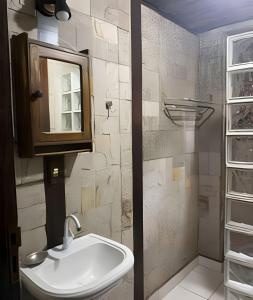 a bathroom with a sink and a mirror at Linda Casa na Praia de Cambury - SP (4) in Boicucanga