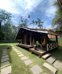 a small house with a porch and grass at Linda Casa na Praia de Cambury - SP (4) in Boicucanga +86 photos