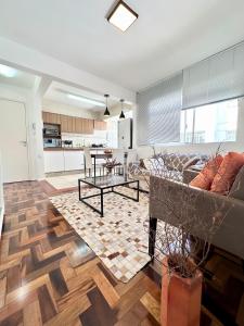a living room with a couch and a kitchen at Barriga Verde in Florianópolis