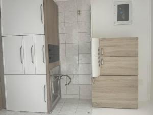 a bathroom with white cabinets and a shower backdoor at House Nikola in Tučepi
