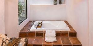 a bathroom with a white sink on a tiled floor at Agua Bendita San Miguel de Allende in San Miguel de Allende +45 photos